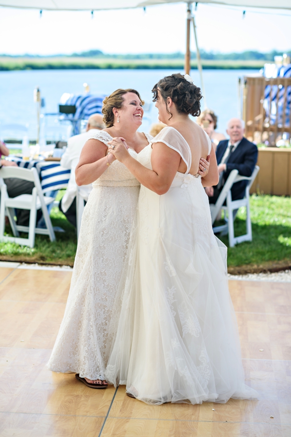 A bride dances with her new wife during their wedding reception.